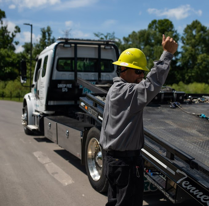 Tow Pro towing technician guiding flatbed tow truck to load a vehicle, showcasing roadside assistance in Nashville, TN.