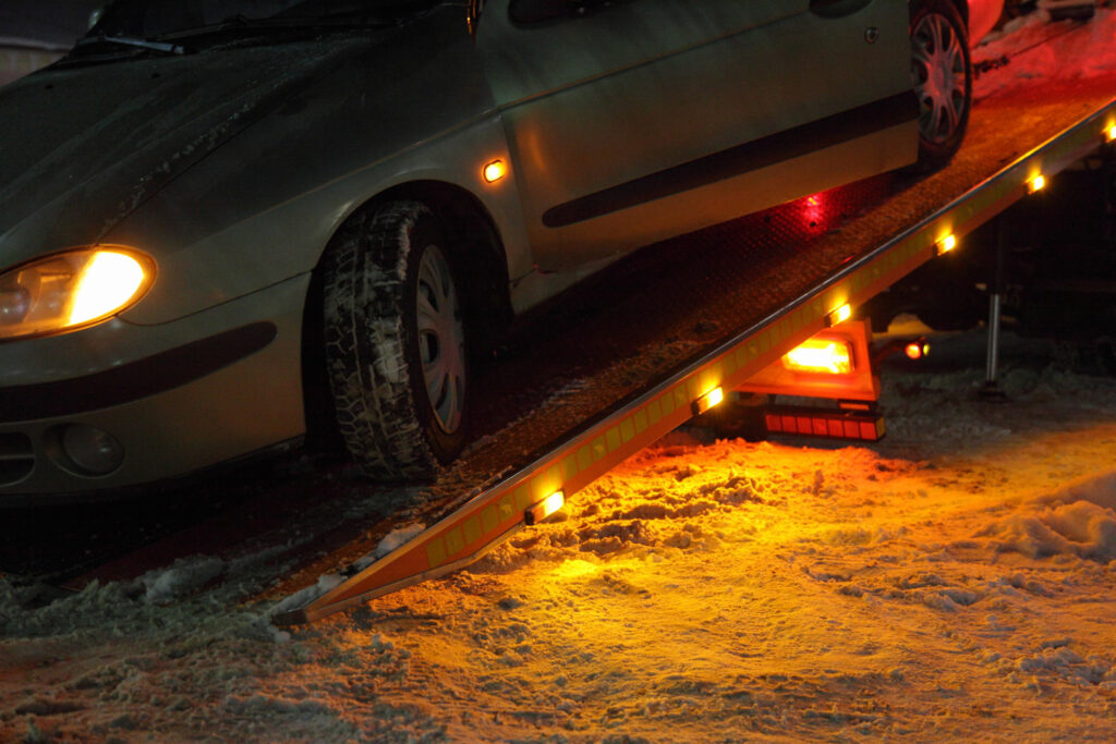 Tow truck providing 24-hour emergency towing services at night.