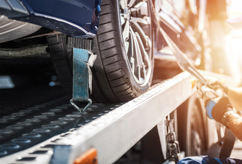 A car safely fastened on a towing truck.